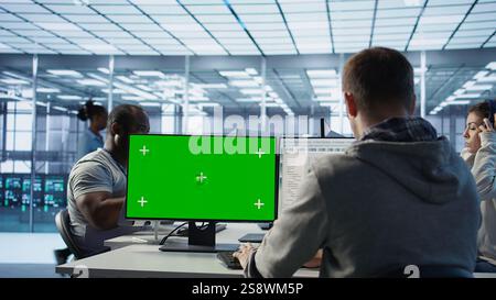 Engineer in server hub using green screen PC to repair equipment storing datasets. Professional using mockup computer to do debugging on rigs doing computational operations, camera B Stock Photo