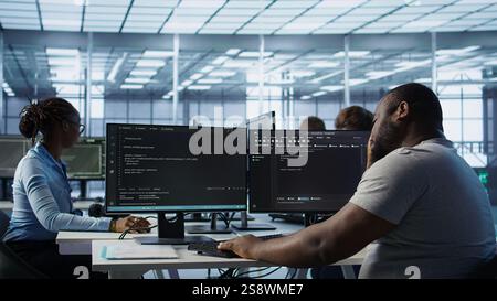 System admin feeling ill, having fever while working in computer network security data center. Sick worker suffering headache while monitoring energy consumption across server racks, camera B Stock Photo