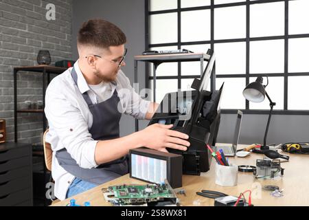 Male technician repairing printer in service center Stock Photo