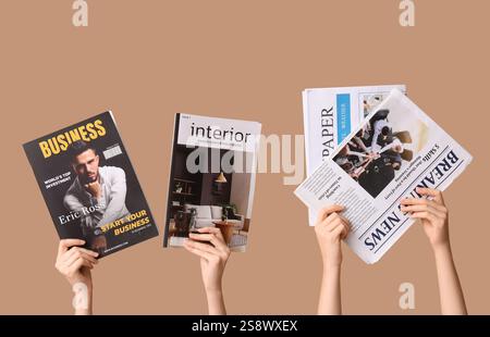 Female hands with different magazines and newspapers on brown background Stock Photo