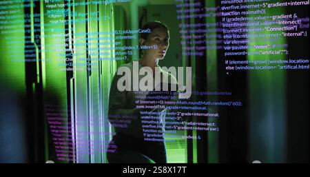 Programming code image over woman using smartphone in server room Stock Photo