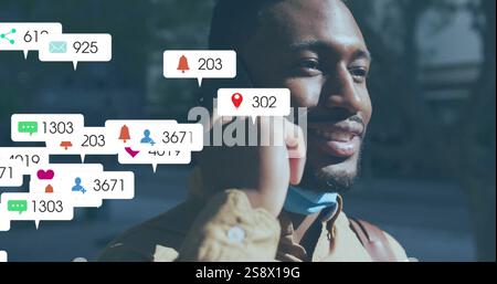 Image of social media notifications over happy african american man talking on smartphone Stock Photo