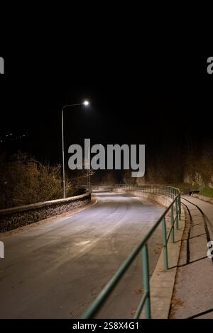 Empty Curved Road with Streetlights at Night Stock Photo