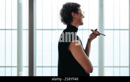 A professional interior designer in a consultation using a smartphone on speaker mode. The modern workspace environment, emphasizes the art of interio Stock Photo