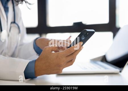 Cropped closeup female medical worker hands using modern mobile phone Stock Photo