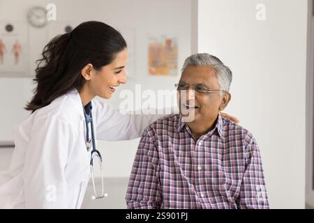 Smiling female medic worker hug shoulder of happy senior patient Stock Photo