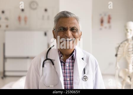Headshot portrait smiling face senior man physician talking by videocall Stock Photo