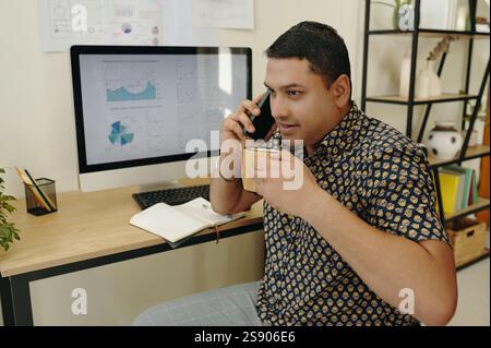Holding Coffee While Discussing Business Over Phone Stock Photo