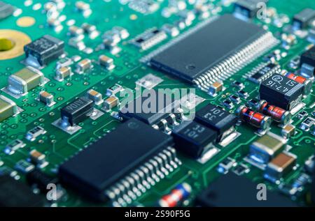 An intricate view of an electronic circuit board displaying various components, including chips and resistors, highlighting its complex design. Stock Photo