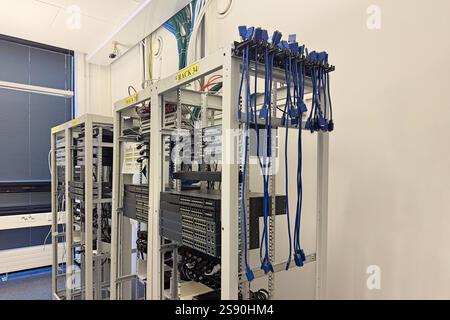 Racks and network cables in high-tech office. Infrastructure, networking, and data storage concept Stock Photo