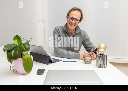 the businessman is smiling while holding his smartphone Stock Photo