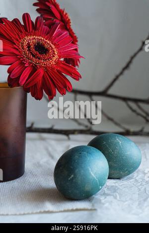 Easter composition with eggs, a vase of gerbera on a calm background. Stock Photo