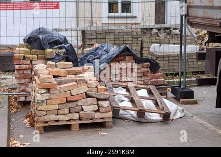 A construction site with bricks and a truck stacked on pallets. Stock Photo