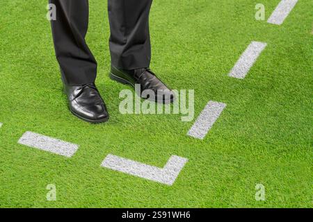 Close up of coach standing next to chalk line on soccer field Stock Photo