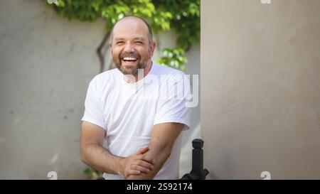 An image of a bearded bald man laughing Stock Photo