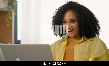 African American shocked ethnic woman freelancer businesswoman using computer happy emotion wonder shock winning online lottery victory luck Stock Photo