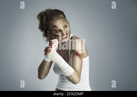 Aggressive female fighter with bruises wearing bloody bandage on her ...