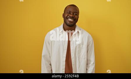 Handsome young man standing over isolated yellow background smiling cheerfully Stock Photo