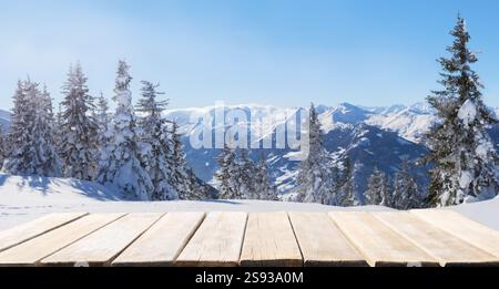Empty old wooden table against snowy firs and winter mountains background. Alps, Italy Stock Photo