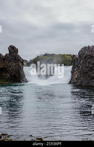 Hjalparfoss waterfall in South Iceland, framed by rugged basalt rocks. Stock Photo