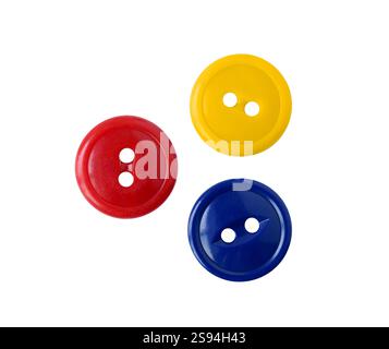 Three red blue and yellow plastic sewing buttons isolated cutout on white Stock Photo