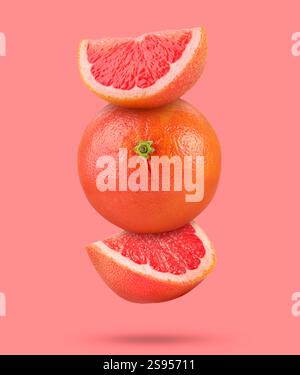 Fresh grapefruits in air on pink background Stock Photo