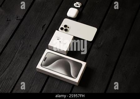 Ukraine Dnipro January 24, 2025 - Apple iPhone 15 Pro Max white and Apple Air Pods 4 with headphones on the table and boxes Stock Photo