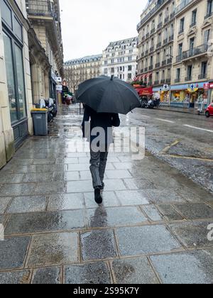 Pedestrian with umbrella in rainy Paris Stock Photo - Alamy