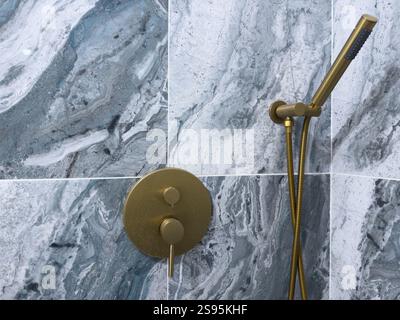 Elegant bathroom design featuring a stylish shower fixture and marble wall Stock Photo