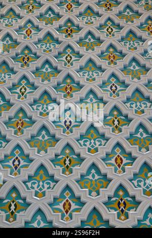 Detail of the white marble decorations in relief against a blue background with floral decorations inside the great mosque of Sultan Qaboos. Stock Photo