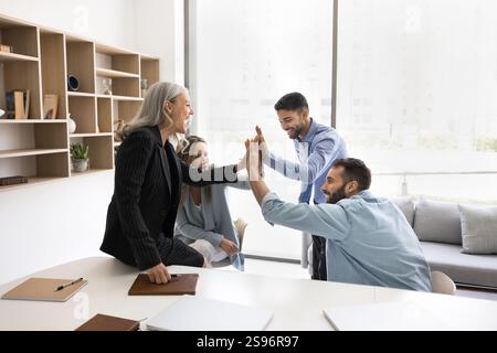 Multiethnic colleagues giving celebratory high-five, gesture of success Stock Photo