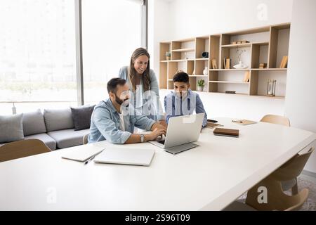 In modern conference room teammates engaged in workflow using laptop Stock Photo