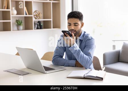 Young 20s man holds smartphone lead talk on speakerphone Stock Photo