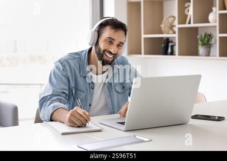 Man take part in online class using laptop and application Stock Photo