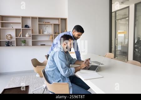 Two male office employees working together on joint online task Stock Photo