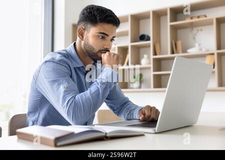 Focused reviewing data, analyzing reports using laptop Stock Photo