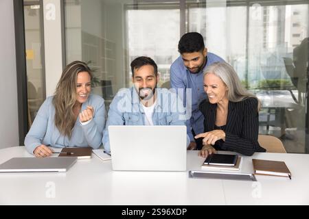 Happy workmates using laptop in conference room Stock Photo
