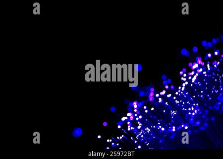 Abstract Fiber Optic Light Bokeh on Black Background, vibrant and abstract image showcasing the glowing tips of fiber optic strands in shades of blue Stock Photo