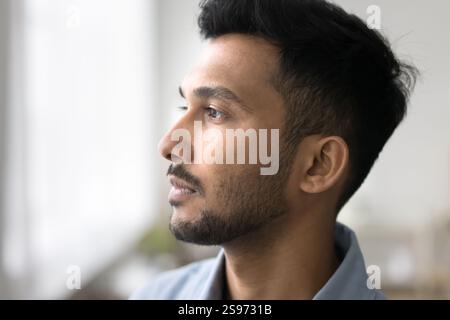 Profile face of pensive young man standing by window Stock Photo