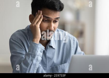 Portrait serious thoughtful young businessman using notebook at online job Stock Photo