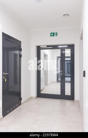 Modern Hallway with Emergency Exit Door and Access Control Stock Photo