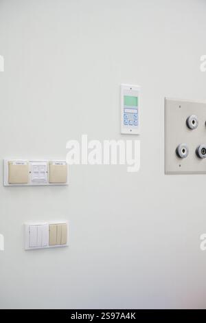 Various Control Panels and Electrical Switches on a White Wall Stock Photo