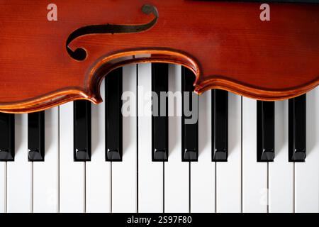 Violin on top of piano keyboard background with copy space for music concept or orchestra concert performance. Stock Photo