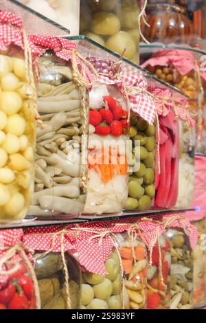 Assorted Jars of Preserved Food Items Displayed on a Shelf in a Market Stock Photo