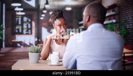 Laughing Male And Female Sitting In Cafe Drinking Coffee And Talking Stock Photo