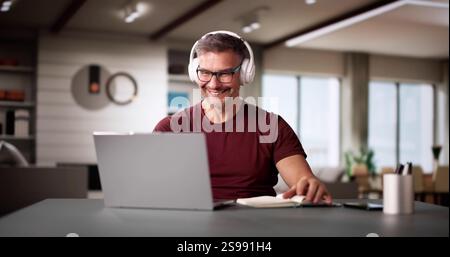 College Teacher At Home Using Laptop Computer Stock Photo
