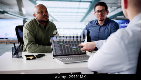 Young Black Programmer Coding On Laptop At Office Late Night. Stock Photo