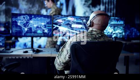 Army Soldier Operates Advanced Computer Technology In Military Technology Center. African American Man Working In Virtual Control Room Online. Stock Photo