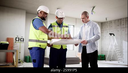 Three professionals inspecting house construction with safety in mind. Stock Photo