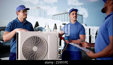 Diverse Group of Workers Installing Air Conditioner on Commercial Building Stock Photo